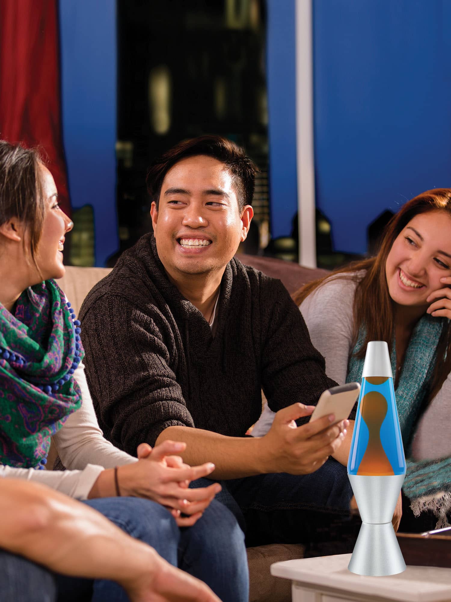 14.5” LAVA® Lamp – Orange/Blue/Silver on a coffee table at a party